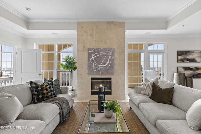 living room featuring ornamental molding, a wealth of natural light, and a fireplace