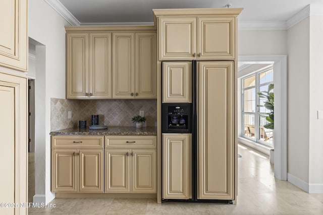 kitchen with crown molding, paneled refrigerator, baseboards, and cream cabinets
