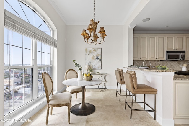 dining area with crown molding, baseboards, and a notable chandelier