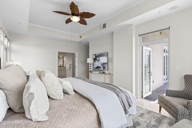 bedroom featuring visible vents, ornamental molding, tile patterned flooring, a tray ceiling, and ensuite bath