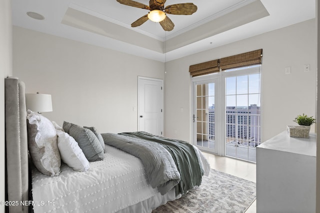 bedroom featuring crown molding, a tray ceiling, access to exterior, and ceiling fan