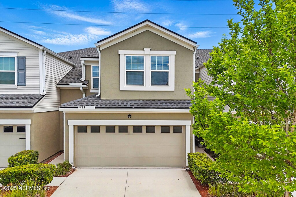 691 Reese Ave, Orange Park, FL 32065 - view of front of home featuring a shingled roof, stucco siding, driveway, and an attached garage