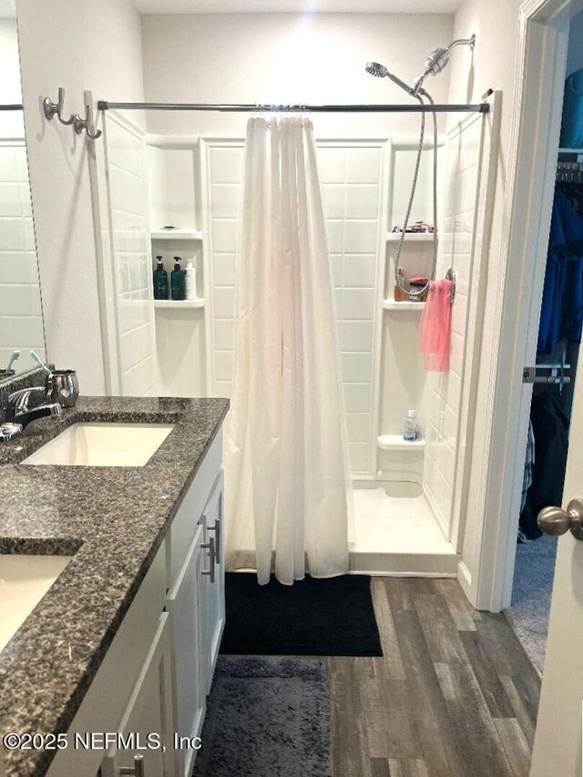 515 S Woodlawn St, Saint Augustine, FL 32084 - bathroom with a stall shower, wood finished floors, double vanity, and a spacious closet