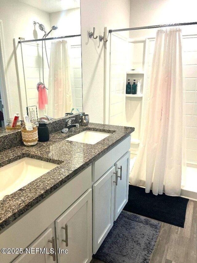 515 S Woodlawn St, Saint Augustine, FL 32084 - bathroom with double vanity, wood finished floors, and tiled shower / bath