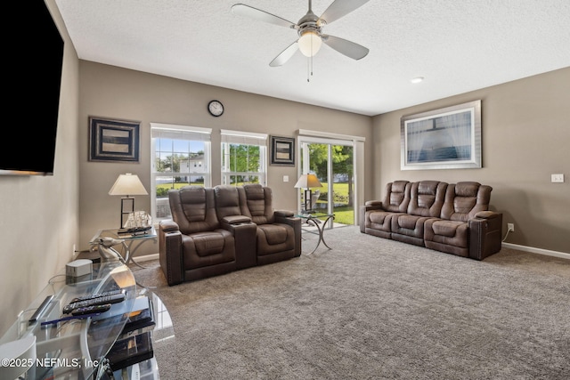 living room featuring carpet flooring, a textured ceiling, ceiling fan, and baseboards