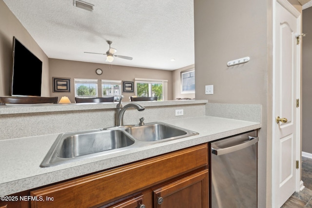 kitchen featuring visible vents, stainless steel dishwasher, light countertops, and a sink