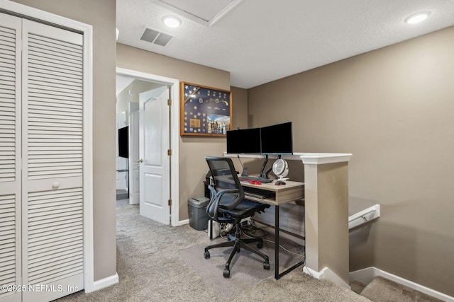 office featuring a textured ceiling, visible vents, baseboards, and carpet floors