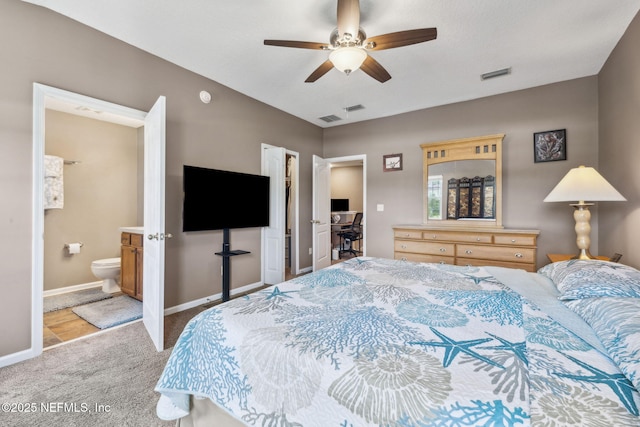 carpeted bedroom featuring baseboards, visible vents, ceiling fan, and connected bathroom