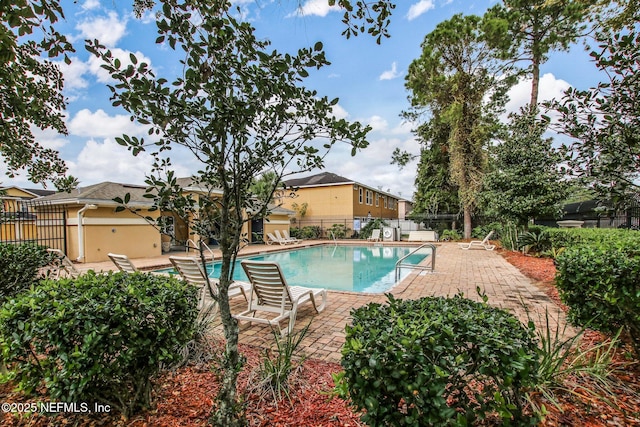 community pool featuring a patio and fence