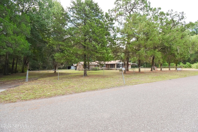 exterior space featuring fence and a front lawn