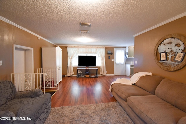 living room with crown molding, a textured ceiling, visible vents, and wood finished floors