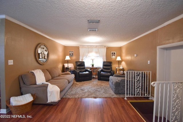 living area featuring visible vents, wood finished floors, a textured ceiling, and ornamental molding