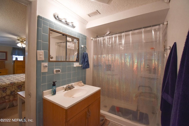 bathroom featuring curtained shower, a textured ceiling, tile walls, and vanity
