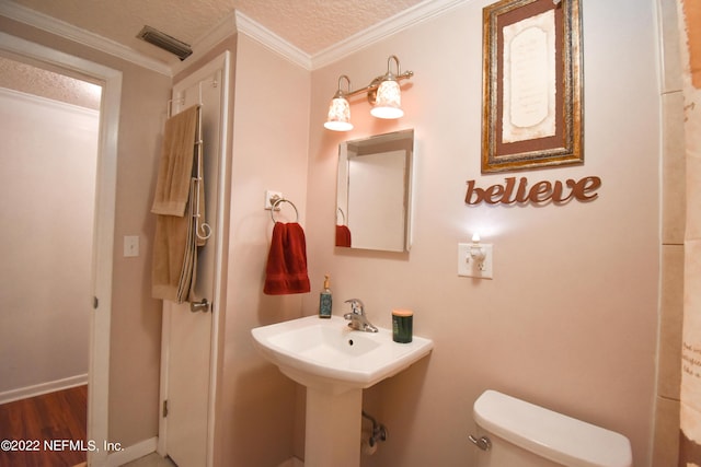 bathroom with wood finished floors, visible vents, toilet, and ornamental molding