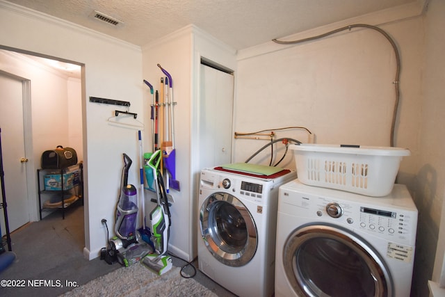 laundry area featuring laundry area, carpet, ornamental molding, visible vents, and washer and clothes dryer