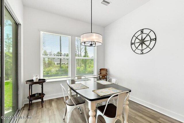 dining area with visible vents, baseboards, and wood finished floors