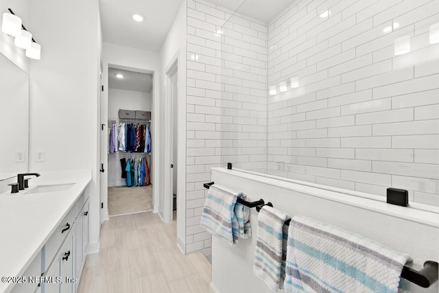 bathroom with vanity, recessed lighting, a walk in shower, and a walk in closet