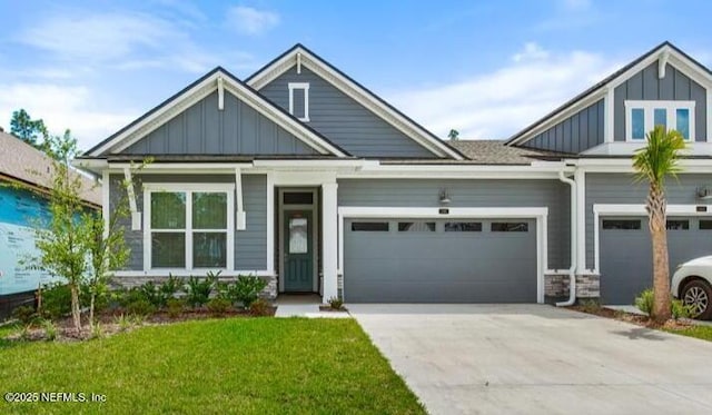 craftsman inspired home featuring a garage, board and batten siding, concrete driveway, and a front lawn