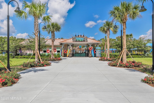 view of property's community with fence, a gate, a gazebo, and concrete driveway