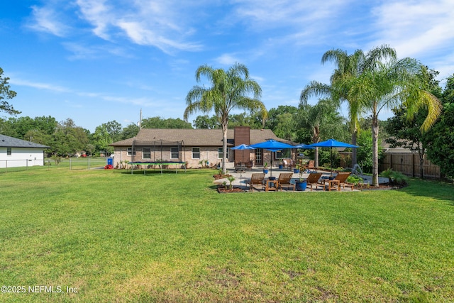 view of yard with a fenced backyard, a patio, and a trampoline