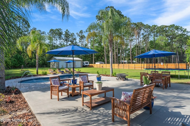 view of home's community with a trampoline, a patio area, a shed, an outbuilding, and a yard