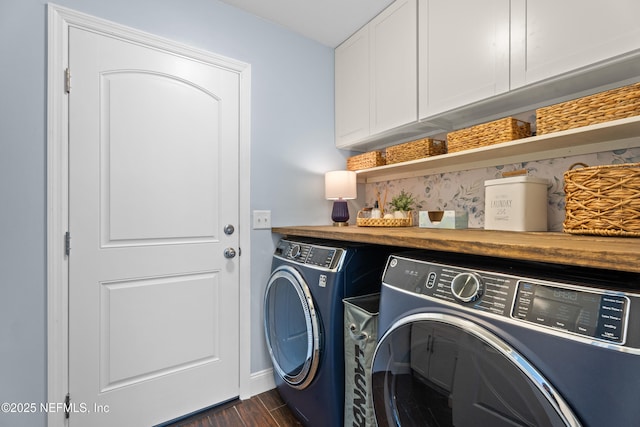 clothes washing area with washer and dryer, cabinet space, baseboards, and dark wood finished floors