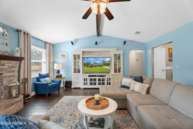 living area with a fireplace, lofted ceiling with beams, ceiling fan, visible vents, and wood finished floors