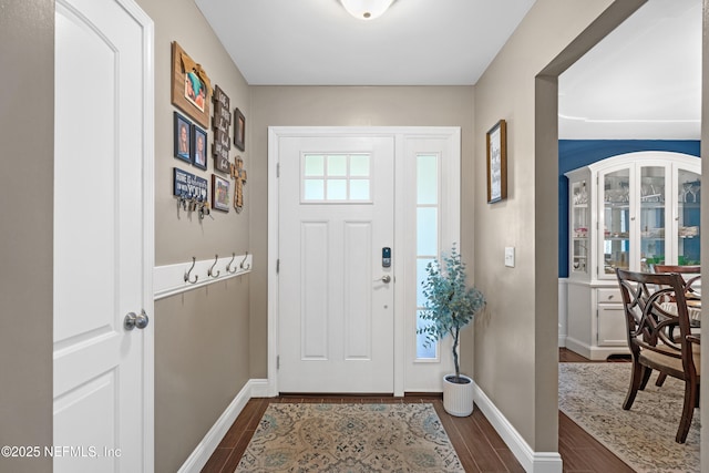 entryway with dark wood-style floors and baseboards