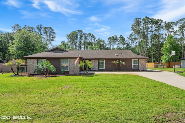 ranch-style home with a front lawn, a shingled roof, brick siding, concrete driveway, and fence