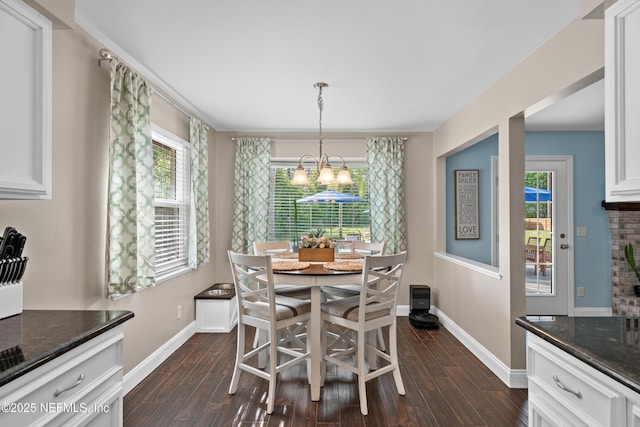 dining area with a chandelier, dark wood finished floors, and baseboards