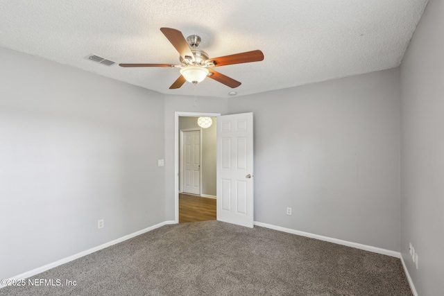 carpeted empty room featuring baseboards, visible vents, and a ceiling fan