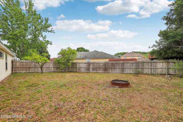 view of yard featuring a fire pit and a fenced backyard