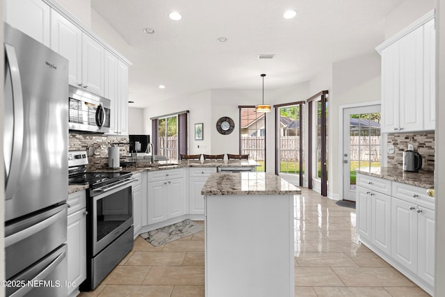 kitchen with tasteful backsplash, stainless steel appliances, a kitchen island, recessed lighting, and a peninsula