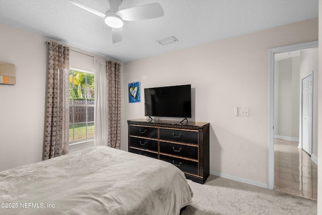 carpeted bedroom with visible vents, ceiling fan, and baseboards