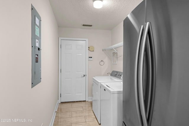 laundry area featuring washing machine and clothes dryer, laundry area, visible vents, baseboards, and a textured ceiling