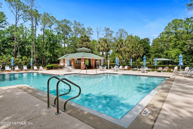 community pool with a patio and fence