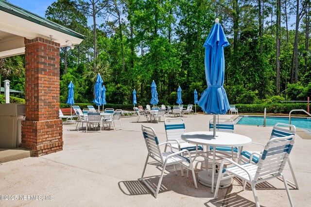view of patio featuring outdoor dining space and a community pool