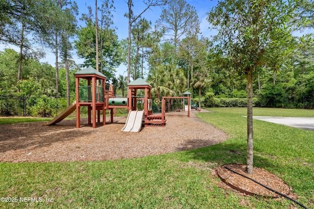 communal playground featuring fence and a lawn