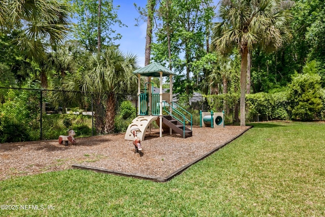 communal playground featuring a yard and fence