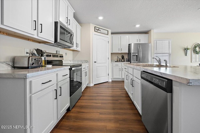 2294 Falling Star Ln, Green Cove Springs, FL 32043 - kitchen featuring appliances with stainless steel finishes, dark wood finished floors, recessed lighting, white cabinetry, and light countertops