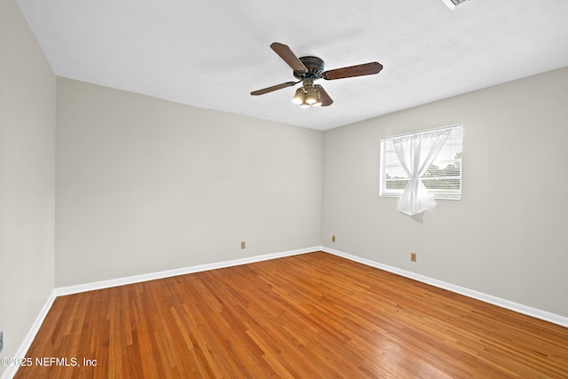 unfurnished room with a ceiling fan, baseboards, and wood finished floors