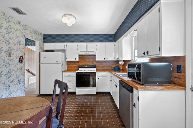 kitchen with visible vents, appliances with stainless steel finishes, under cabinet range hood, wallpapered walls, and white cabinetry