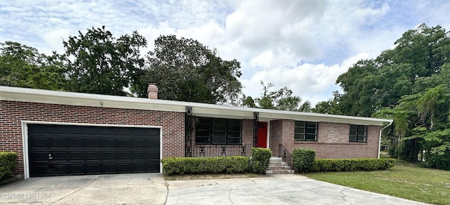 1118 Brookmont Ave E, Jacksonville, FL 32211 - ranch-style house featuring concrete driveway, an attached garage, brick siding, and a chimney