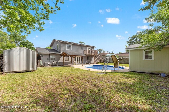 back of property with a deck, stairway, an outbuilding, a storage shed, and central AC