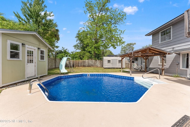 view of swimming pool with an outdoor structure, a fenced backyard, a gazebo, a water slide, and a patio