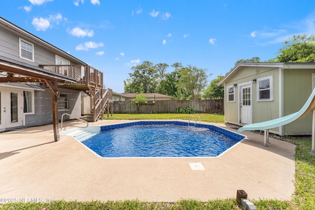 view of swimming pool with a water slide, stairway, a patio, and a fenced backyard