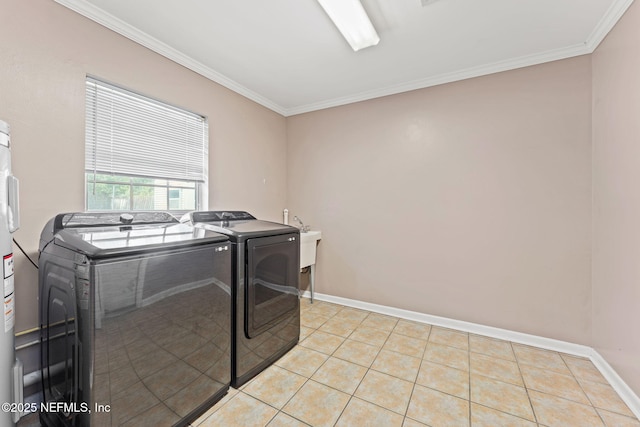 clothes washing area featuring laundry area, light tile patterned floors, baseboards, washer and clothes dryer, and crown molding