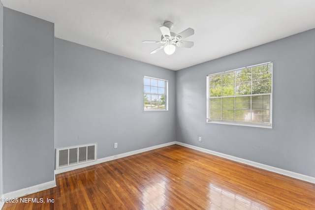 unfurnished room featuring visible vents, ceiling fan, wood-type flooring, and baseboards
