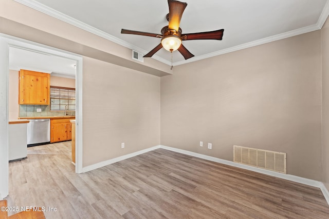 unfurnished room with a sink, light wood-style floors, ceiling fan, crown molding, and visible vents