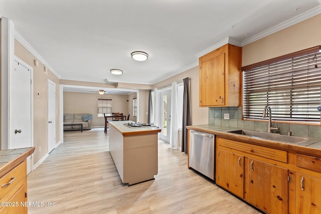 kitchen with stainless steel dishwasher, light wood-style flooring, crown molding, a sink, and tile counters